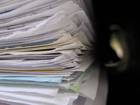 Hoher Stapel Papierdokumente mit farbigen Blättern in einem Aktenordner