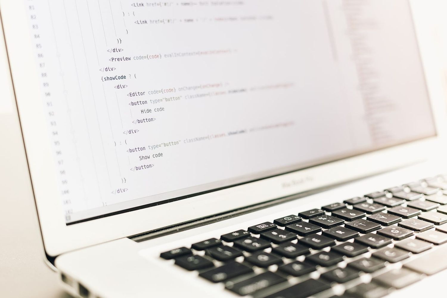 Laptop-Bildschirm mit JavaScript- und JSX-Quellcode in einem Code-Editor